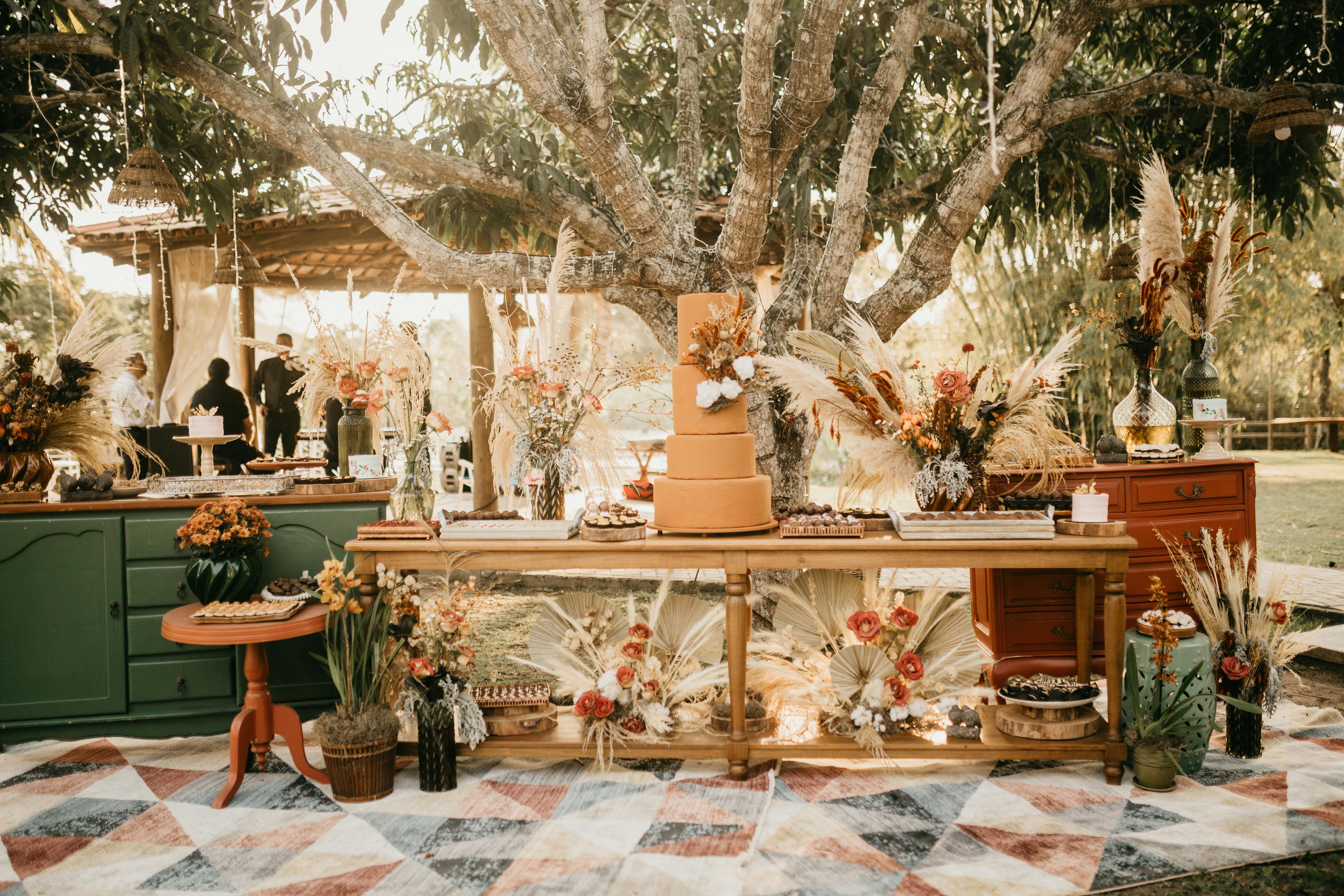 Boho wedding dessert table with modern floral arrangements and event styling