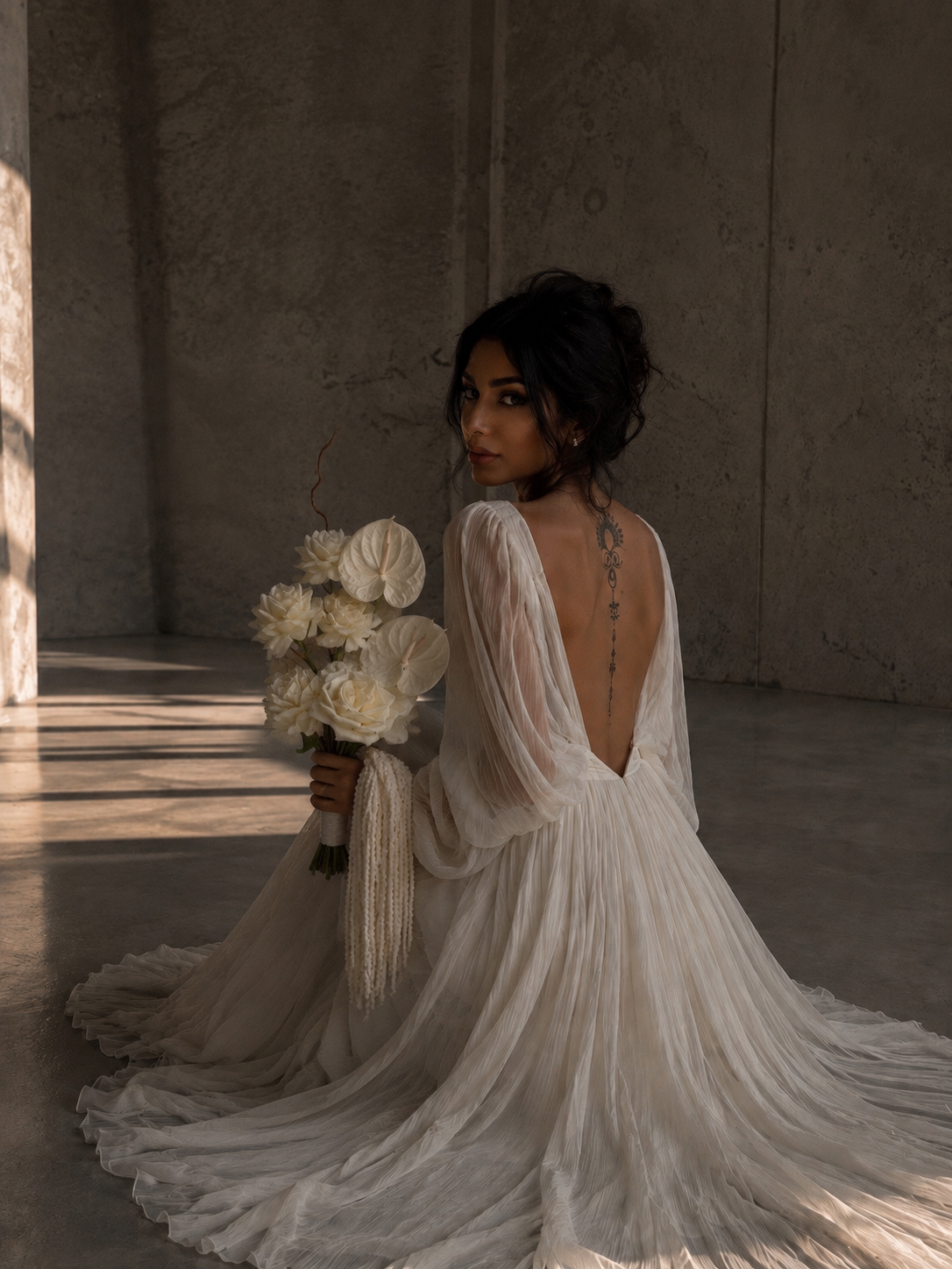 Editorial bride holding a modern white wedding bouquet in a minimal setting