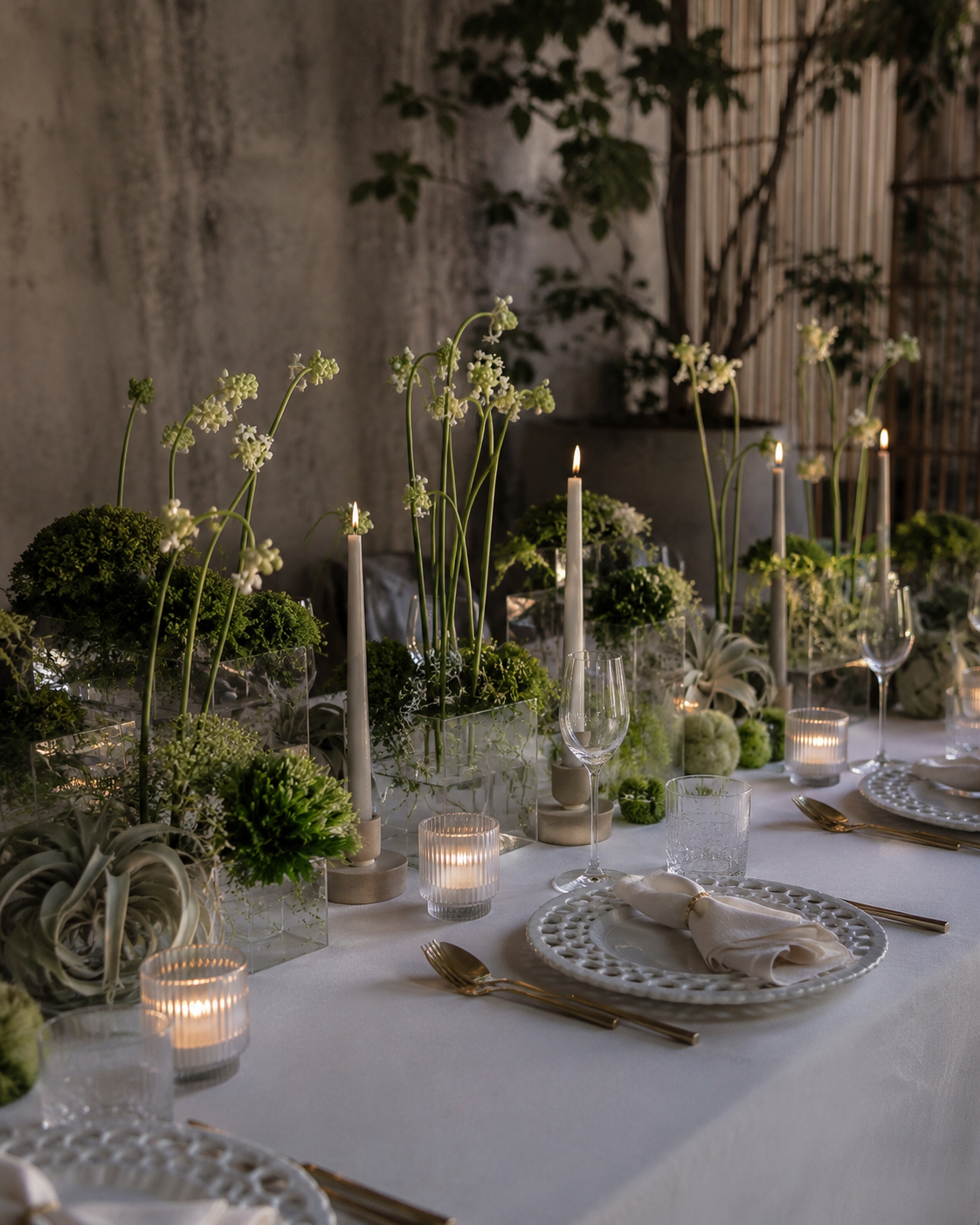 Contemporary event tablescape featuring sculptural floral arrangements and candlelight styling